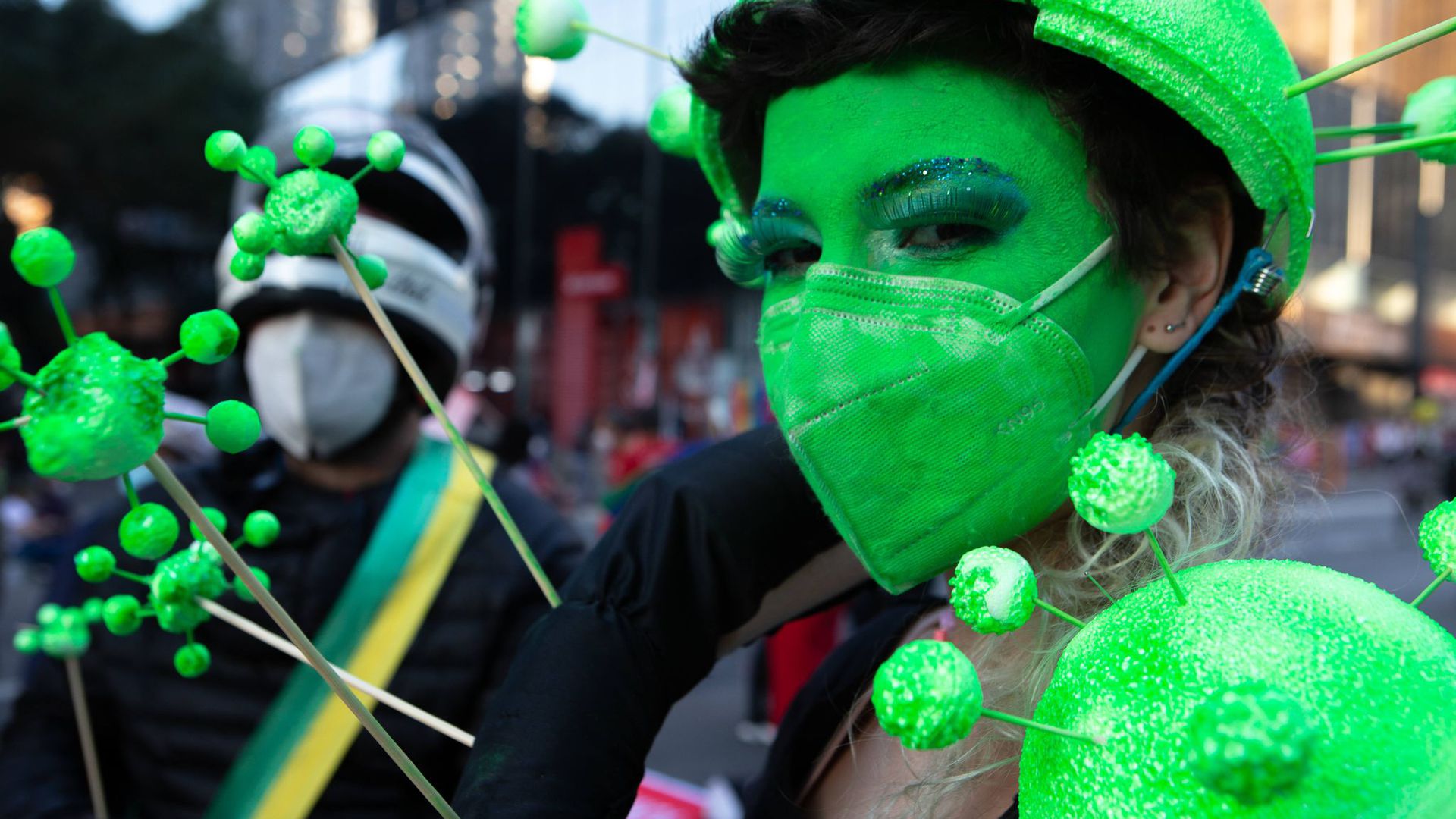 Ein Demonstrantin hat sich ihr Gesicht grün geschminkt und trägt eine grüne Schutzmaske. Tausende Brasilianer sind erneut gegen die Corona-Politik der Regierung von Bolsonaro auf die Straße gegangen.