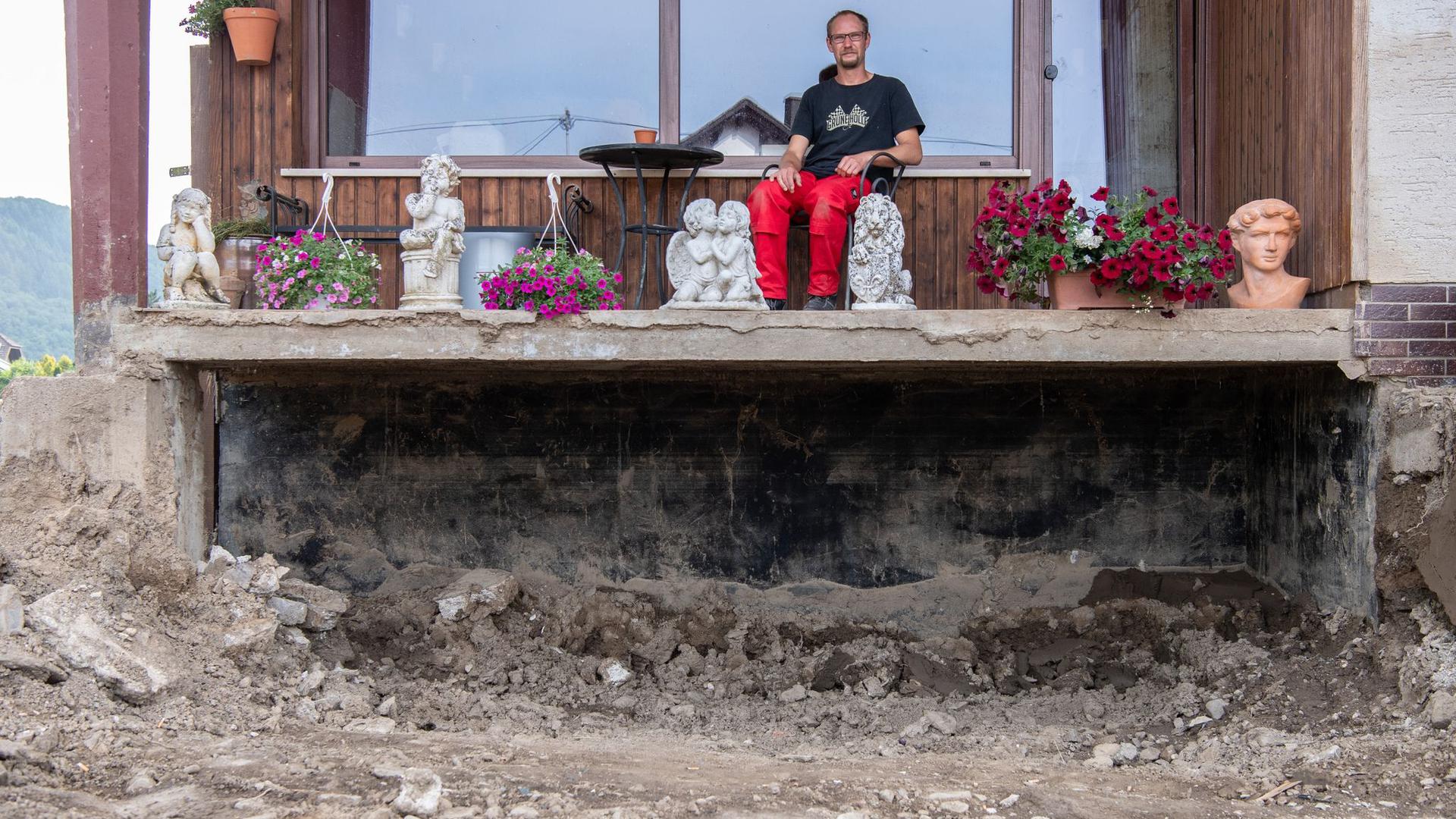 Daniel Schmitz sitzt auf dem Balkon seiner durch die Flut zerstörten Wohnung. Vom einst liebevoll gestalteten Garten ist nichts mehr übrig geblieben.