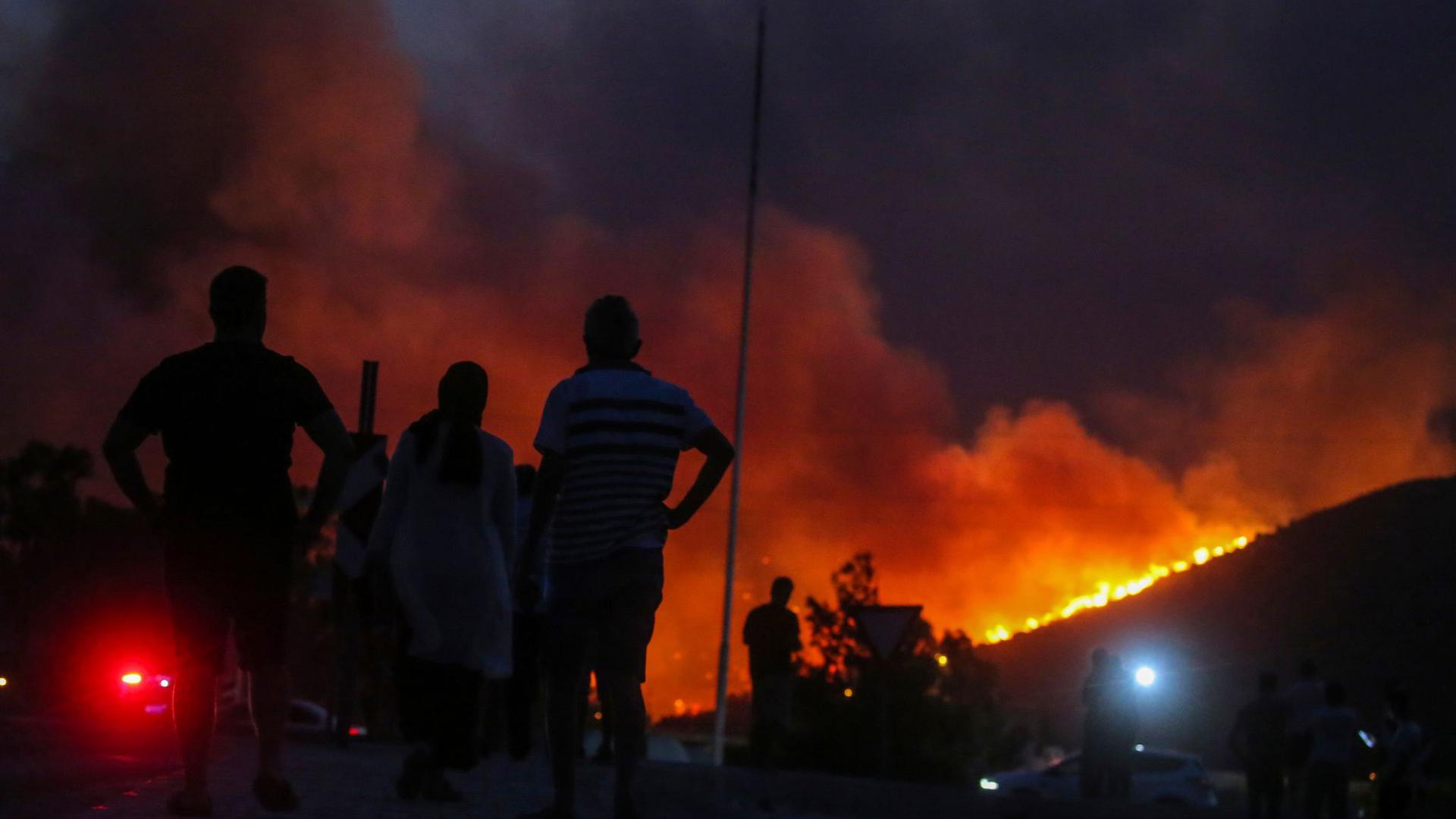 Anwohner beobachten im türkischen Milas die Flammenfront am Horizont.