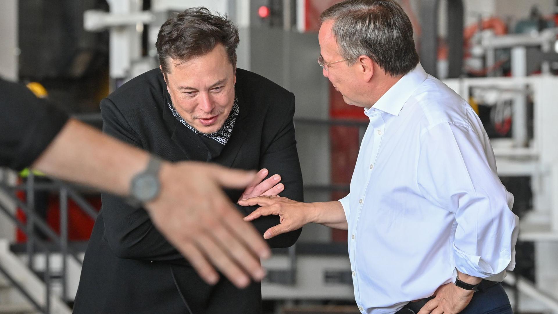 Tesla-Chef Elon Musk (l) und der CDU-Bundesvorsitzende Armin Laschet besichtigen zusammen die künftige Gießerei der Tesla-„Gigafactory“.