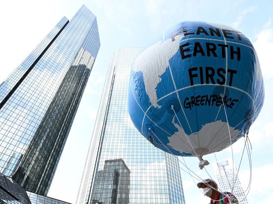 Ein Demonstrant hält einen großen Ballon mit dem Schriftzug „Planet Earth First“ beim zentralen Klimastreik von Fridays for Future in  Frankfurter hoch.