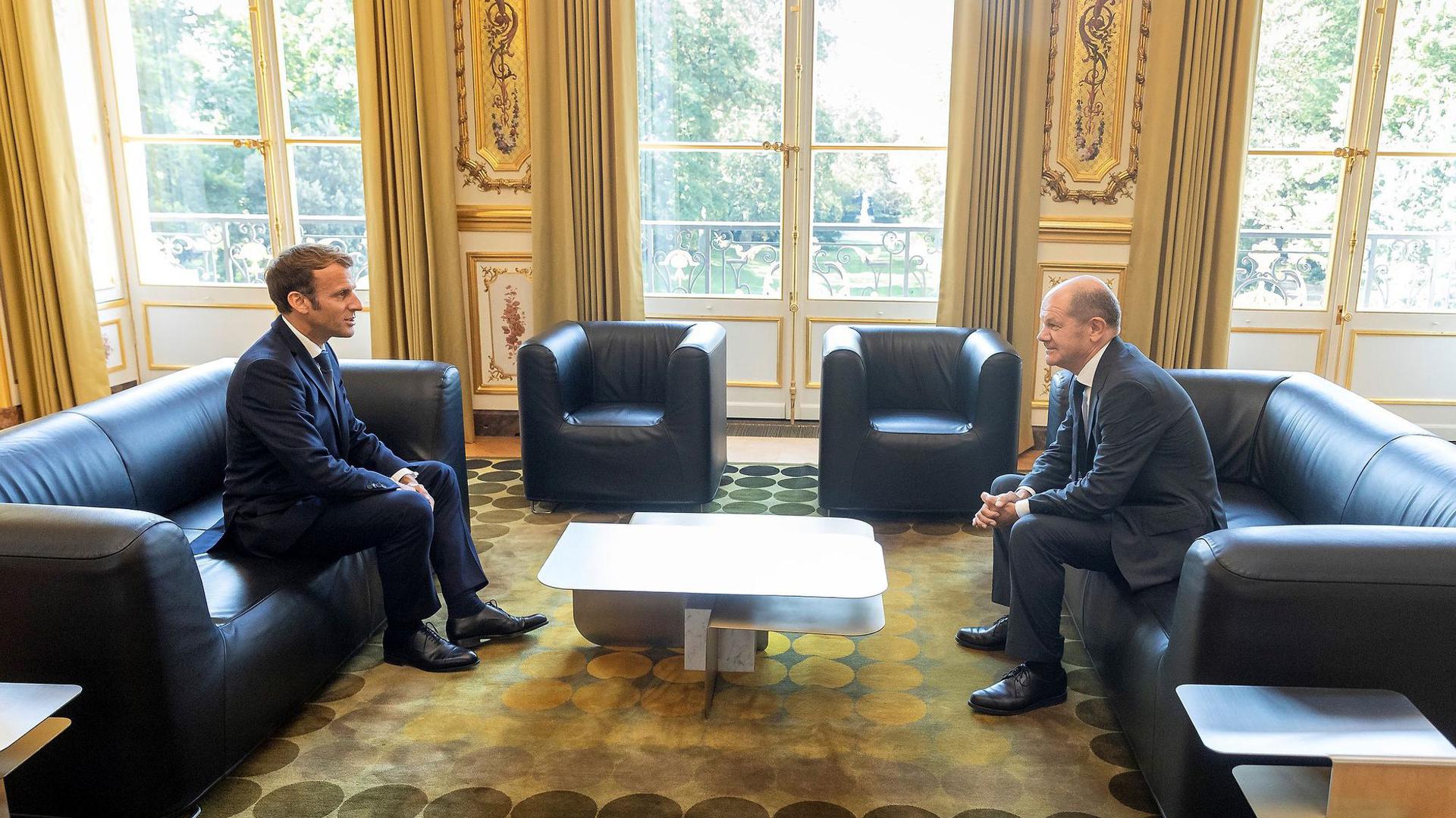 Emmanuel Macron (l.), Präsident von Frankreich, spricht mit Olaf Scholz (SPD), Bundesfinanzminister, im Elysee-Palast.