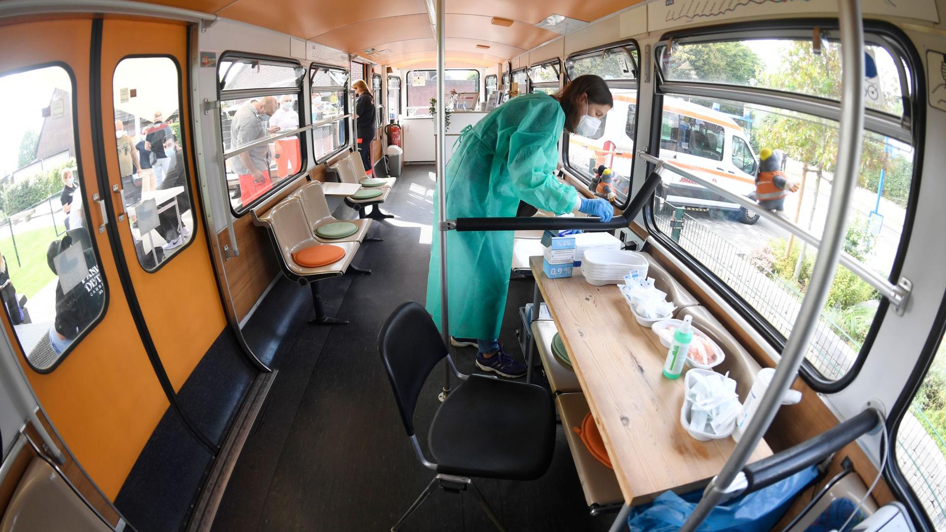 Eine medizisch-technische Assistentin bereitet in einem stillgelegten Schwebebahnwagen in Wuppertal Corona-Impfungen vor. Eine bundesweite Impfaktionswoche soll neue Fortschritte bringen.