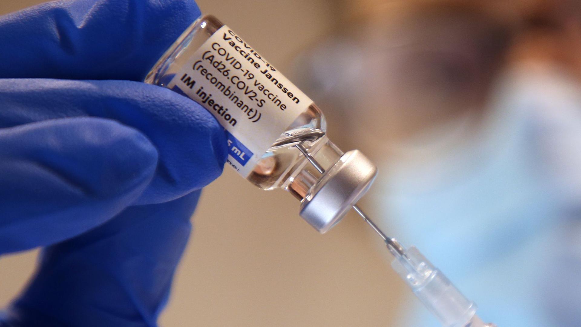 Eine Arzthelferin zieht in einer Praxis eine Spritze mit dem Corona-Impfstoff Janssen von Johnson-&-Johnson auf.
