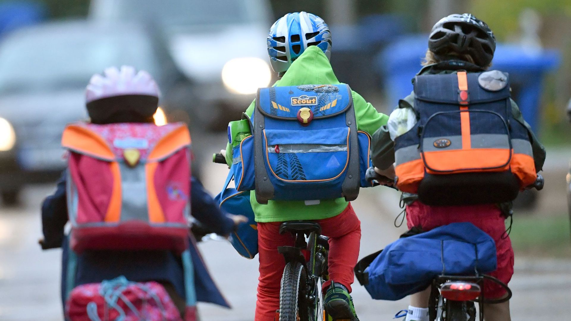 Kinder sind auf einer Straße mit dem Fahrrad unterwegs zur Schule. (Archivbild)