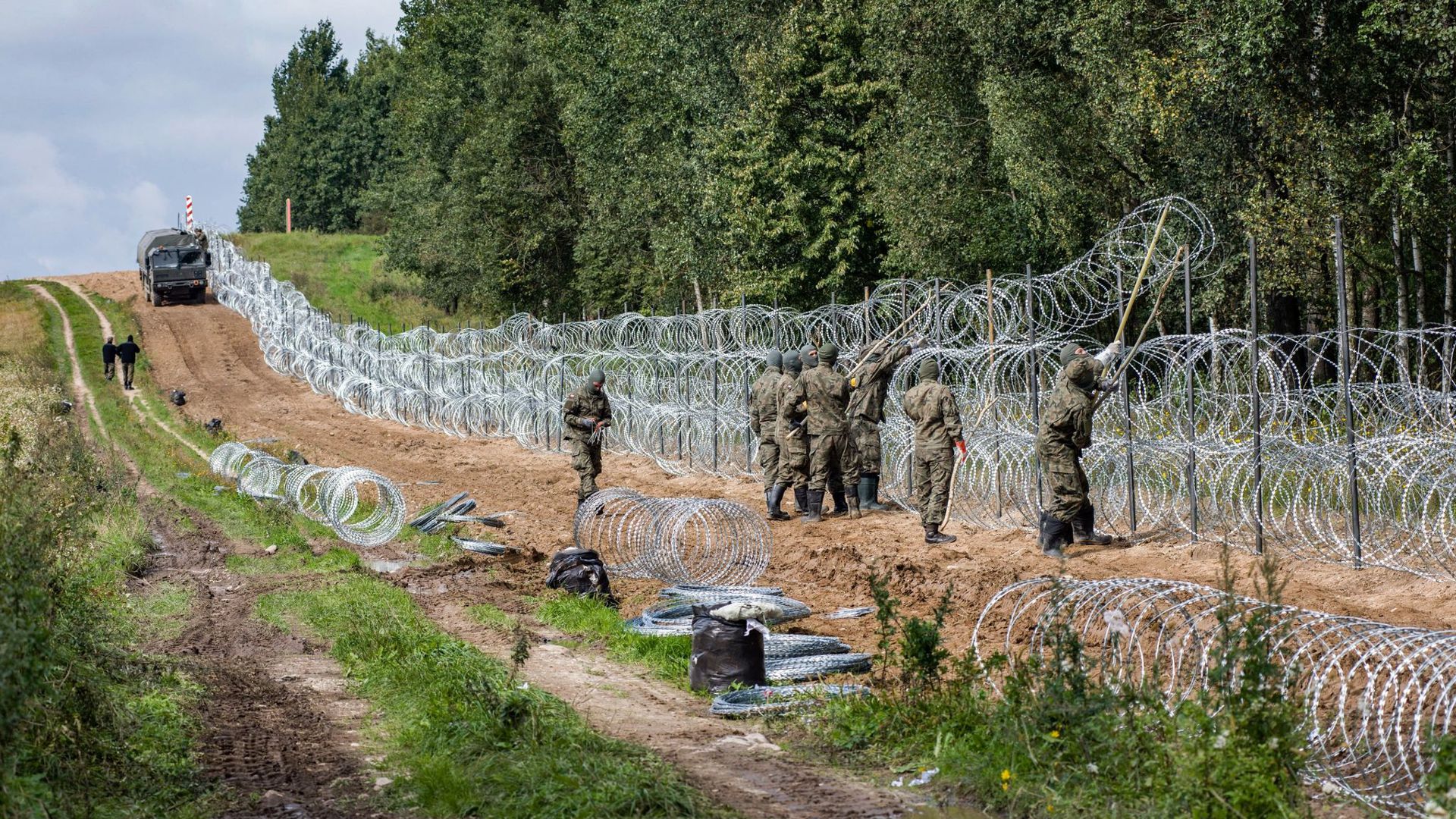 Polnische Soldaten errichten einen Stacheldrahtzaun Grenze zu Belarus (Archiv).