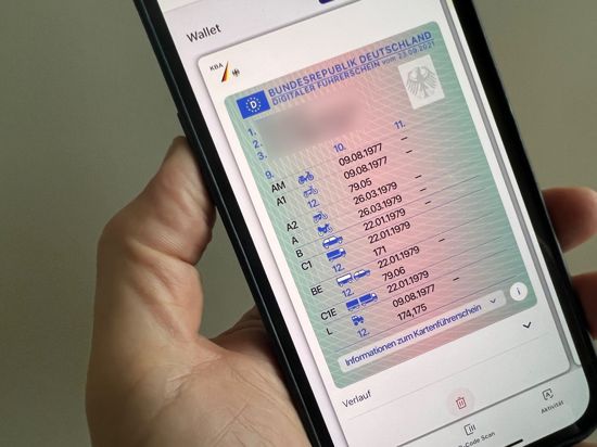 Ein Mann hält ein iPhone mit der App „ID Wallet“, in der die digitale Variante eines Führerscheins zu sehen ist.