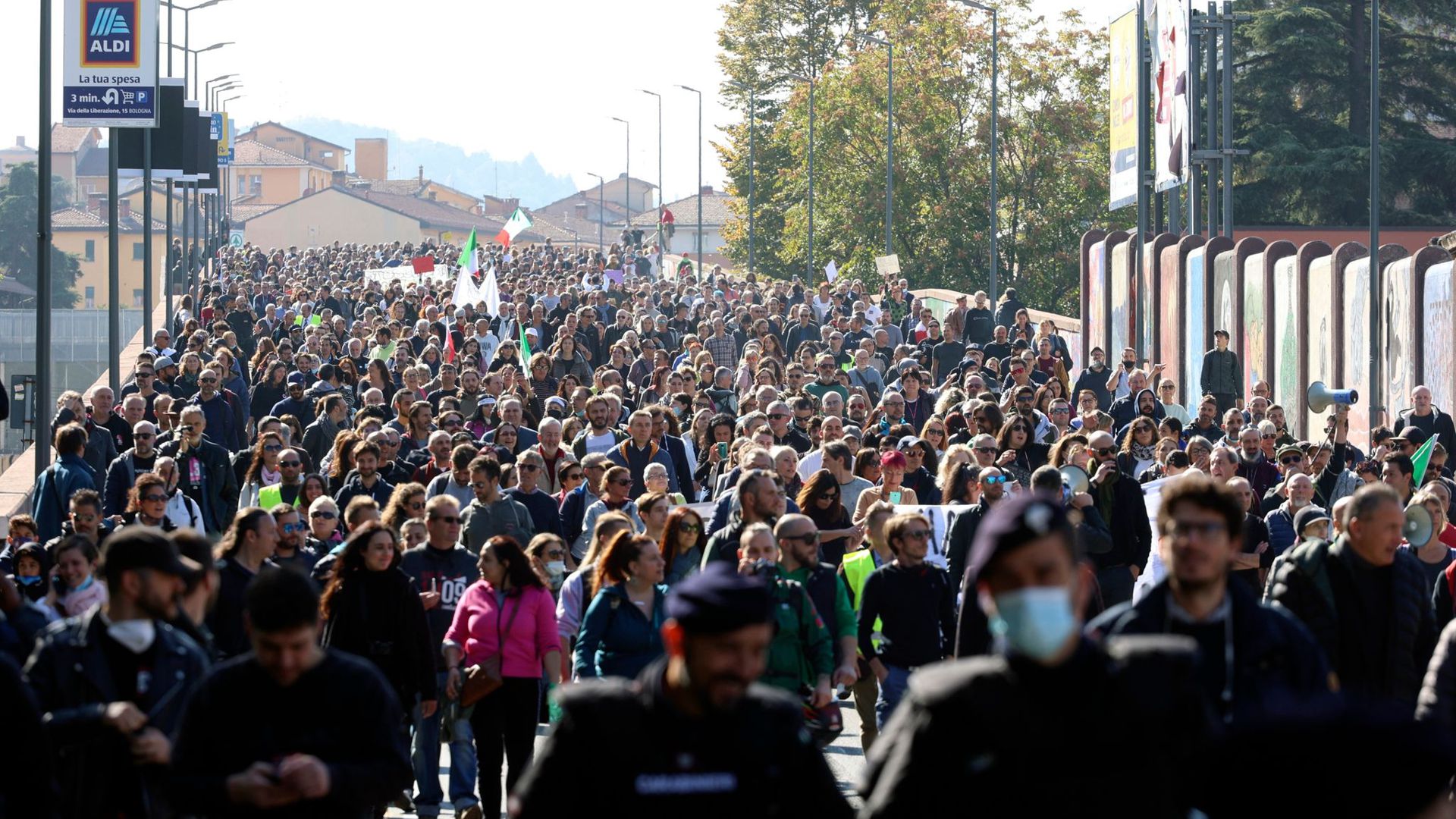 Protestteilnehmer sind in Bologna mit Fahnen auf der Straße, um gegen den sogenannten „Grünen Pass“ zu demonstrieren.