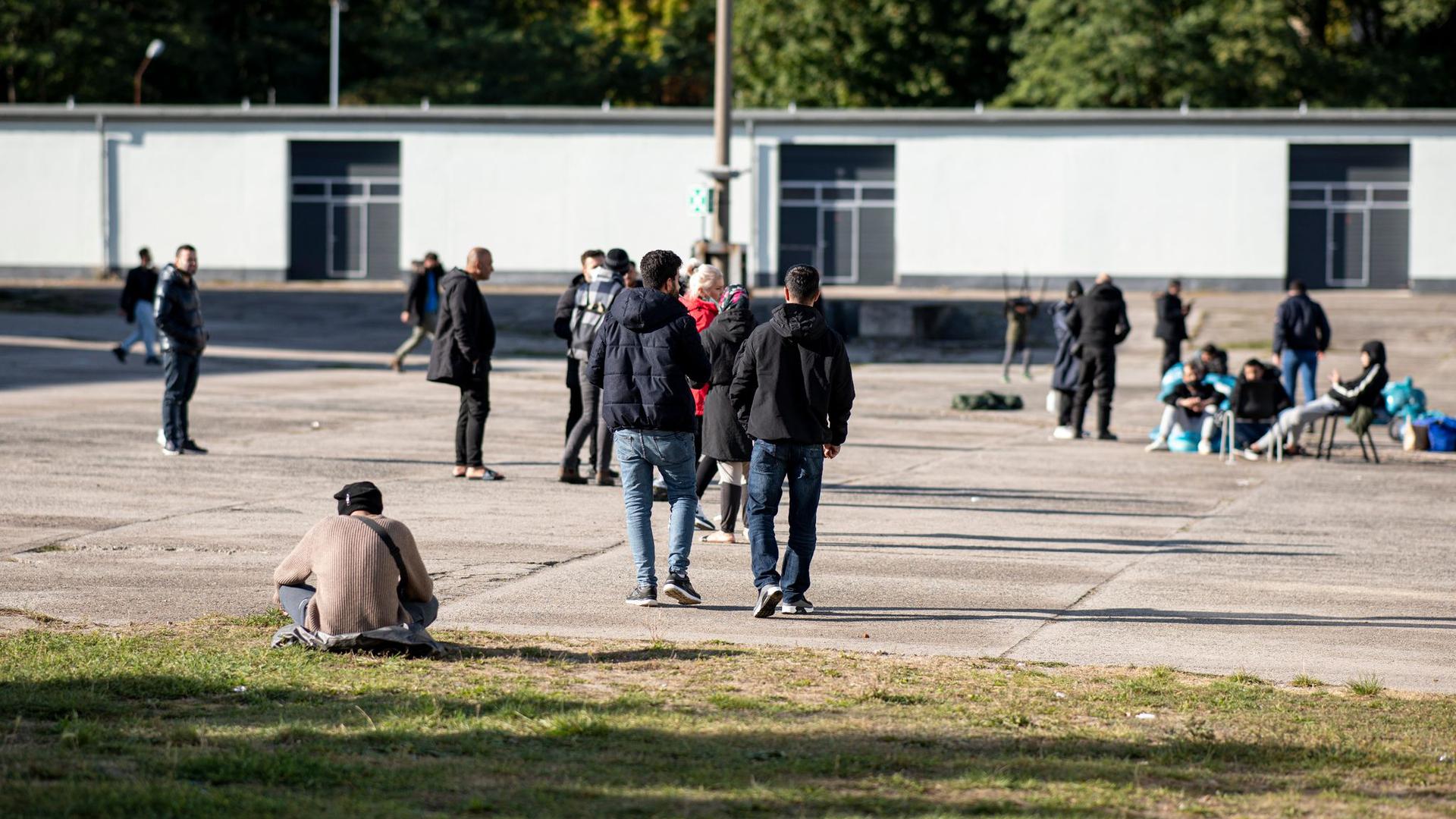 Asylsuchende laufen in der Erstaufnahmeeinrichtung Eisenhüttenstadt über einen Platz. (Archivbild)
