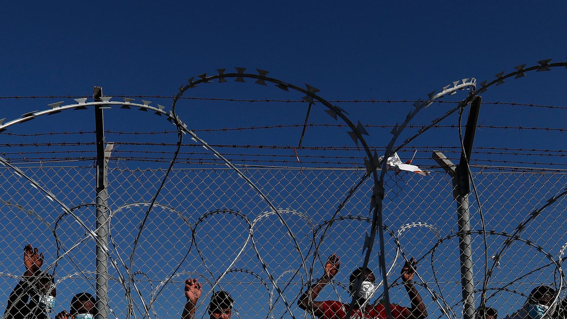 Migranten stehen hinter einem Zaun in einem Flüchtlingslager in Kokkinotrimithia außerhalb Zyperns Hauptstadt Nikosia.