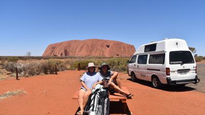 Menekse (l) und James Humphrey neben ihrem Van und vor dem Uluru (Ayers Rock) im Outback Australiens.