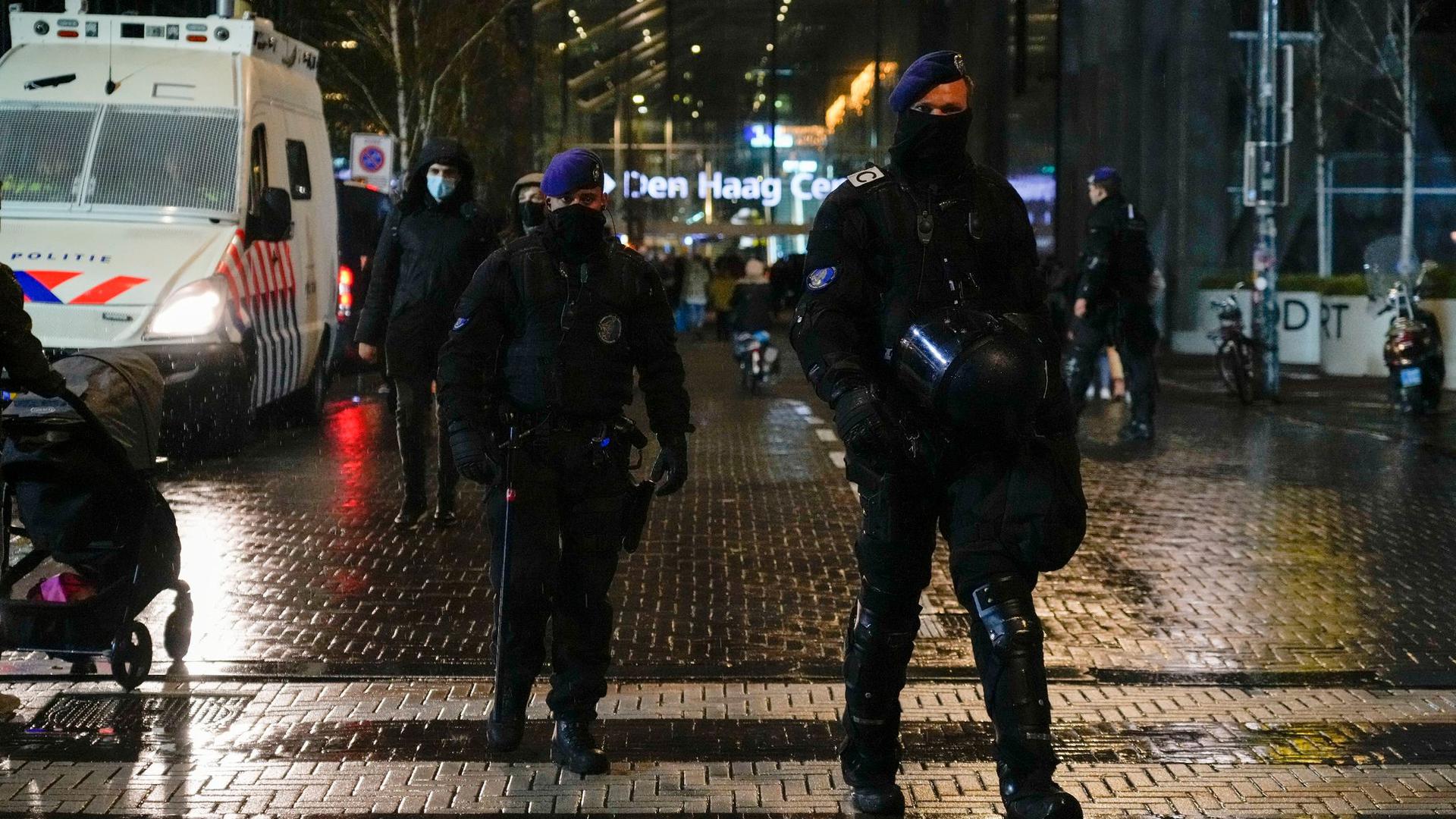 Niederländische Polizisten patrouillieren vor einem Ministeriumsgebäude.