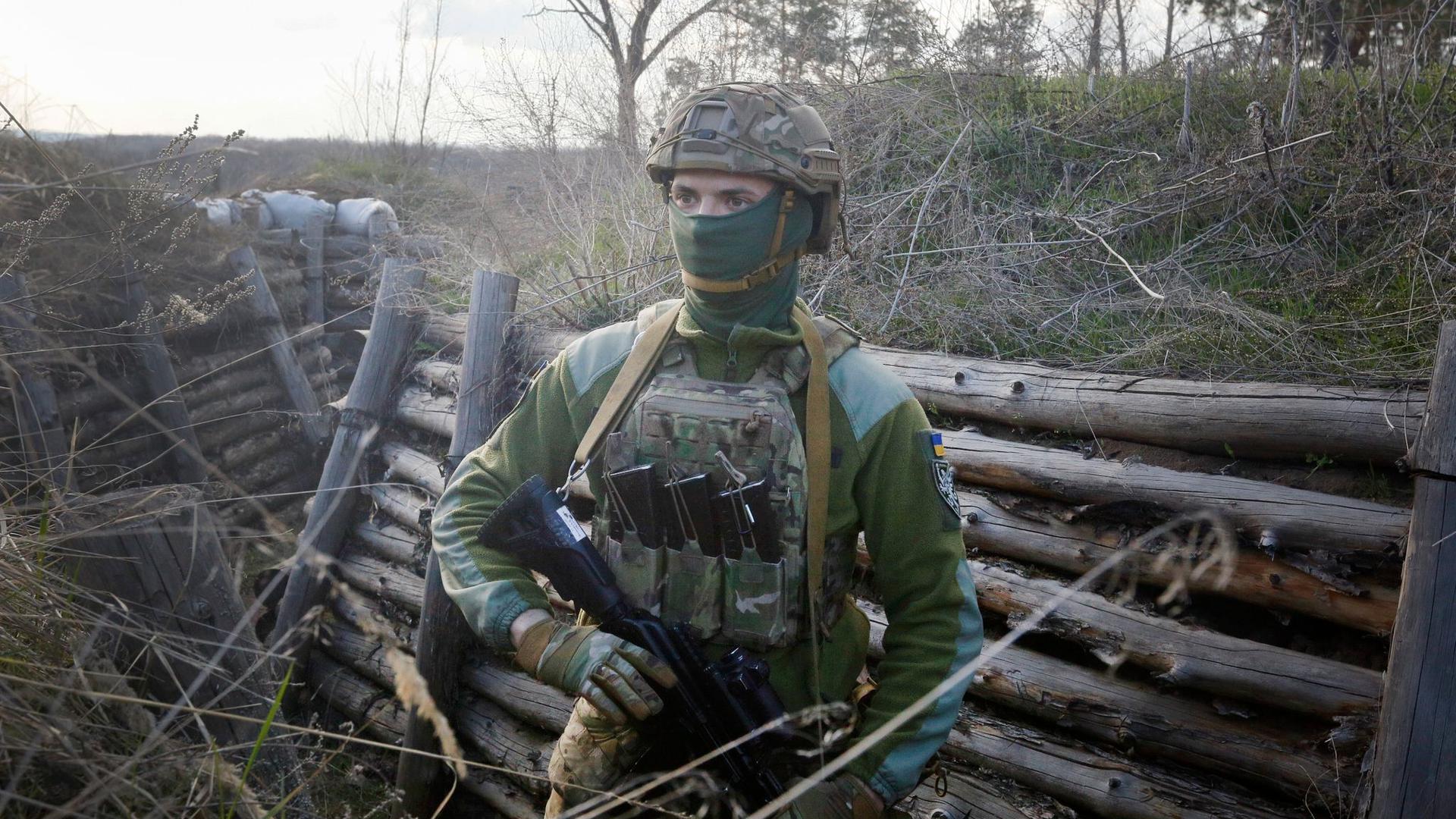 Ein bewaffneter ukrainischer Soldat in einer Kampfstellung an der Trennlinie zum pro-russischen Separatistengebiet.