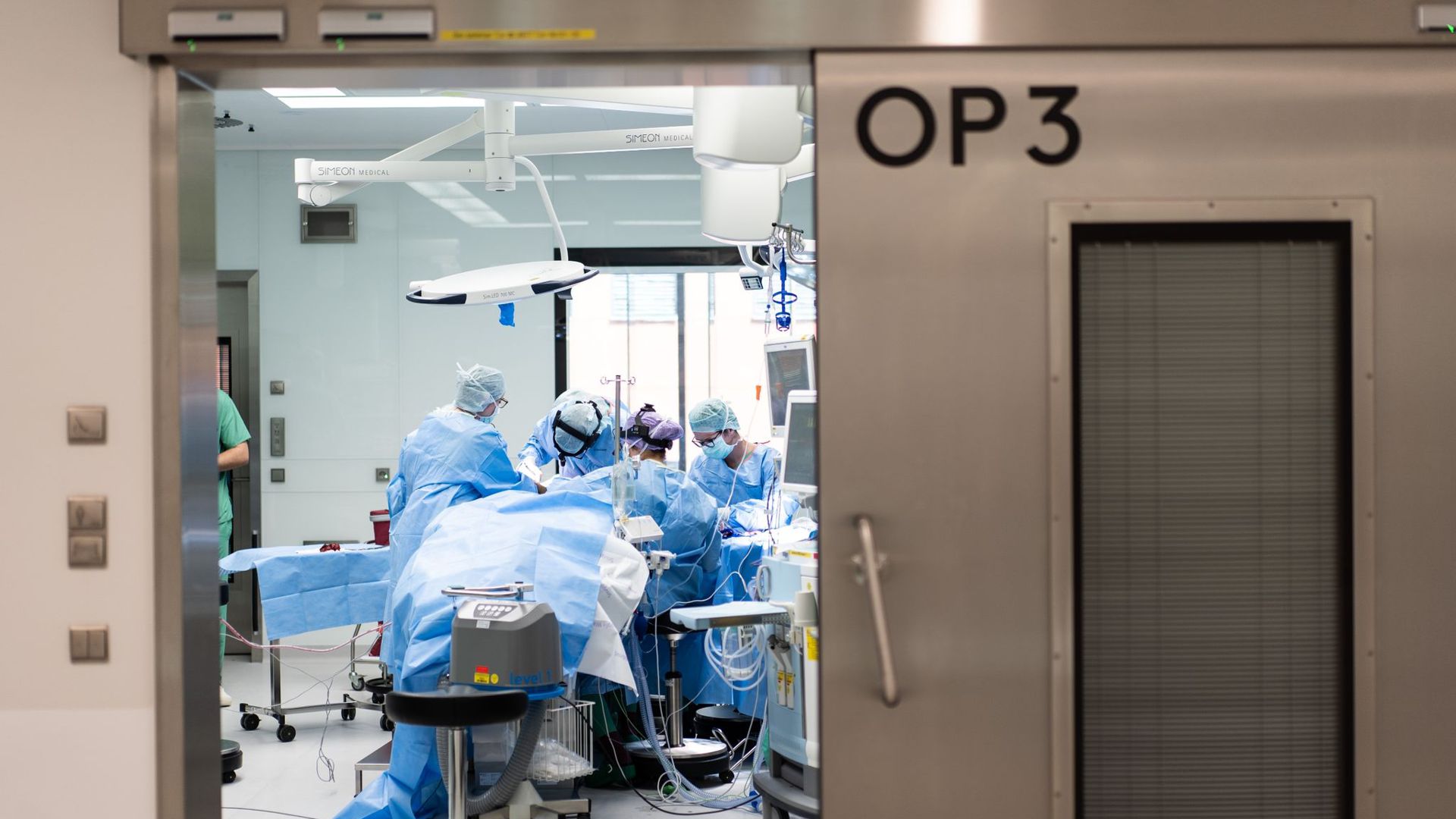 Ein Team aus Ärzten und OP-Helfern in einem Operationssaal eines Universitätsklinikums.