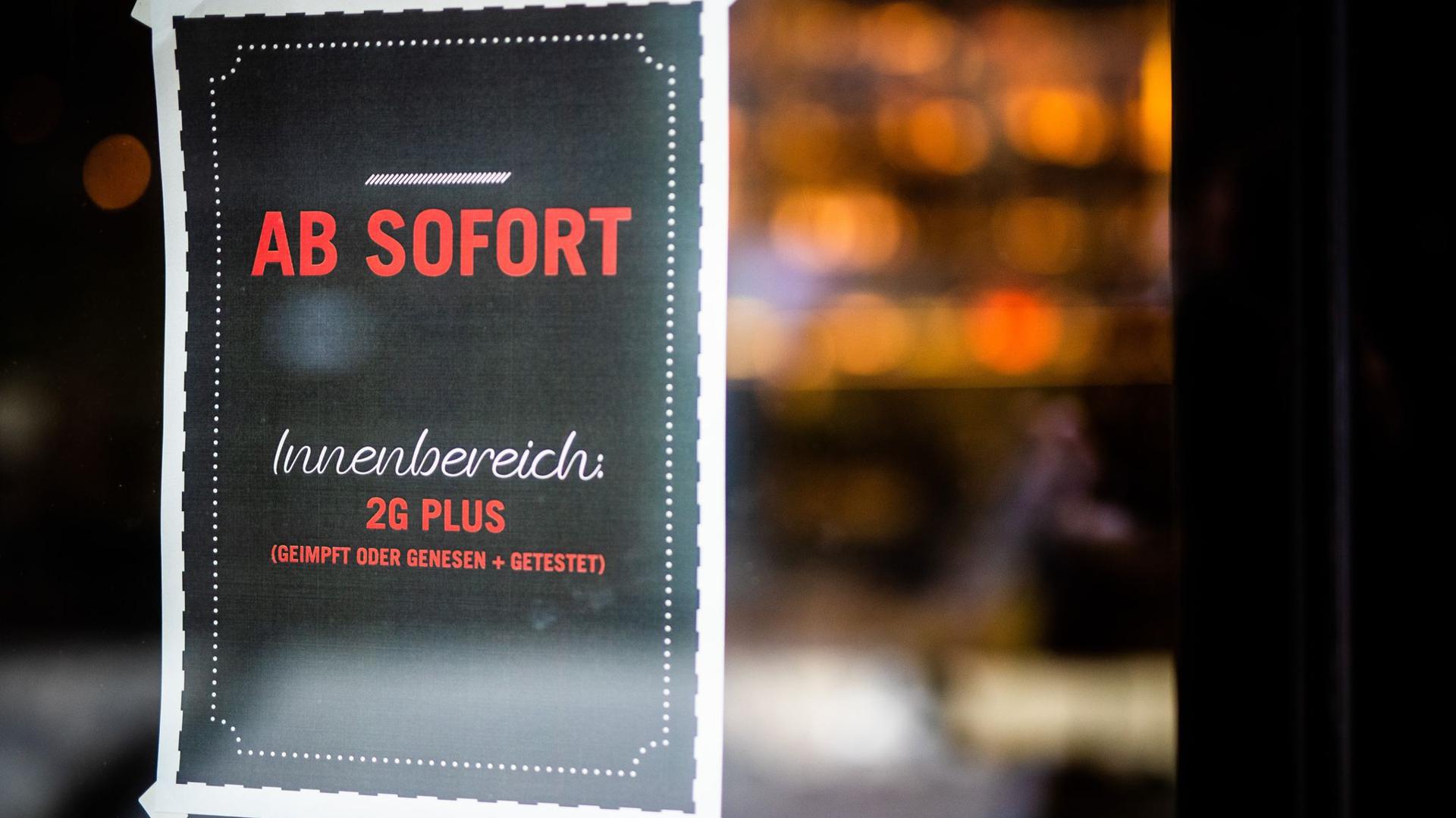 Ein Plakat weist Gäste am Eingang eines Restaurants in Stuttgart auf die neue 2G Plus Regel hin.