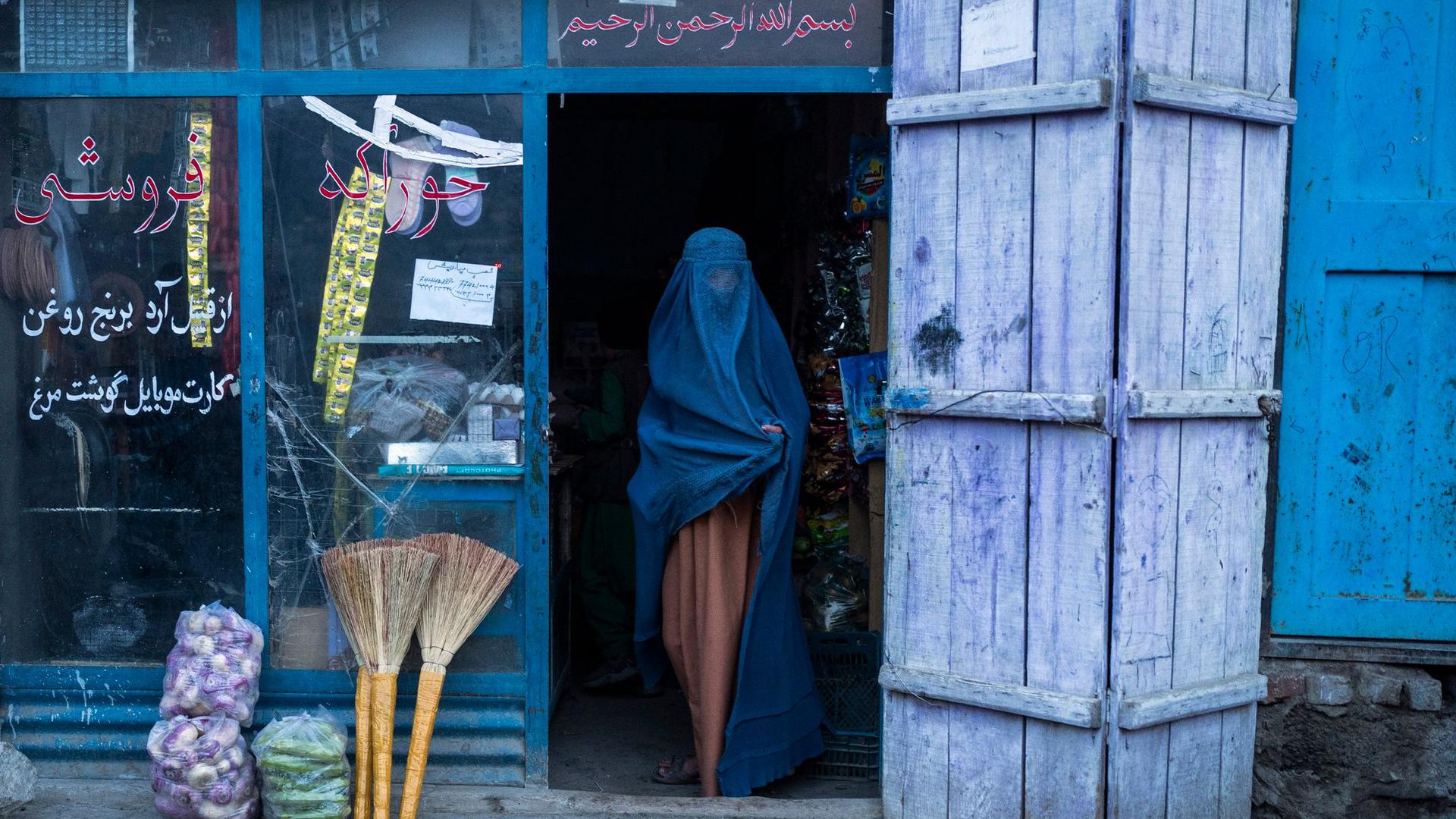 Eine afghanische Frau, die eine Burka trägt, verlässt einen kleinen Laden in Kabul (Archivbild).