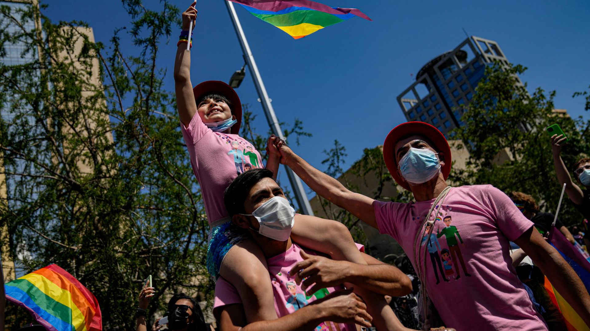Eine Familie nimmt fahnenschwenkend an der jährlichen Gay Pride Parade in Chiles Hauptstadt teil.