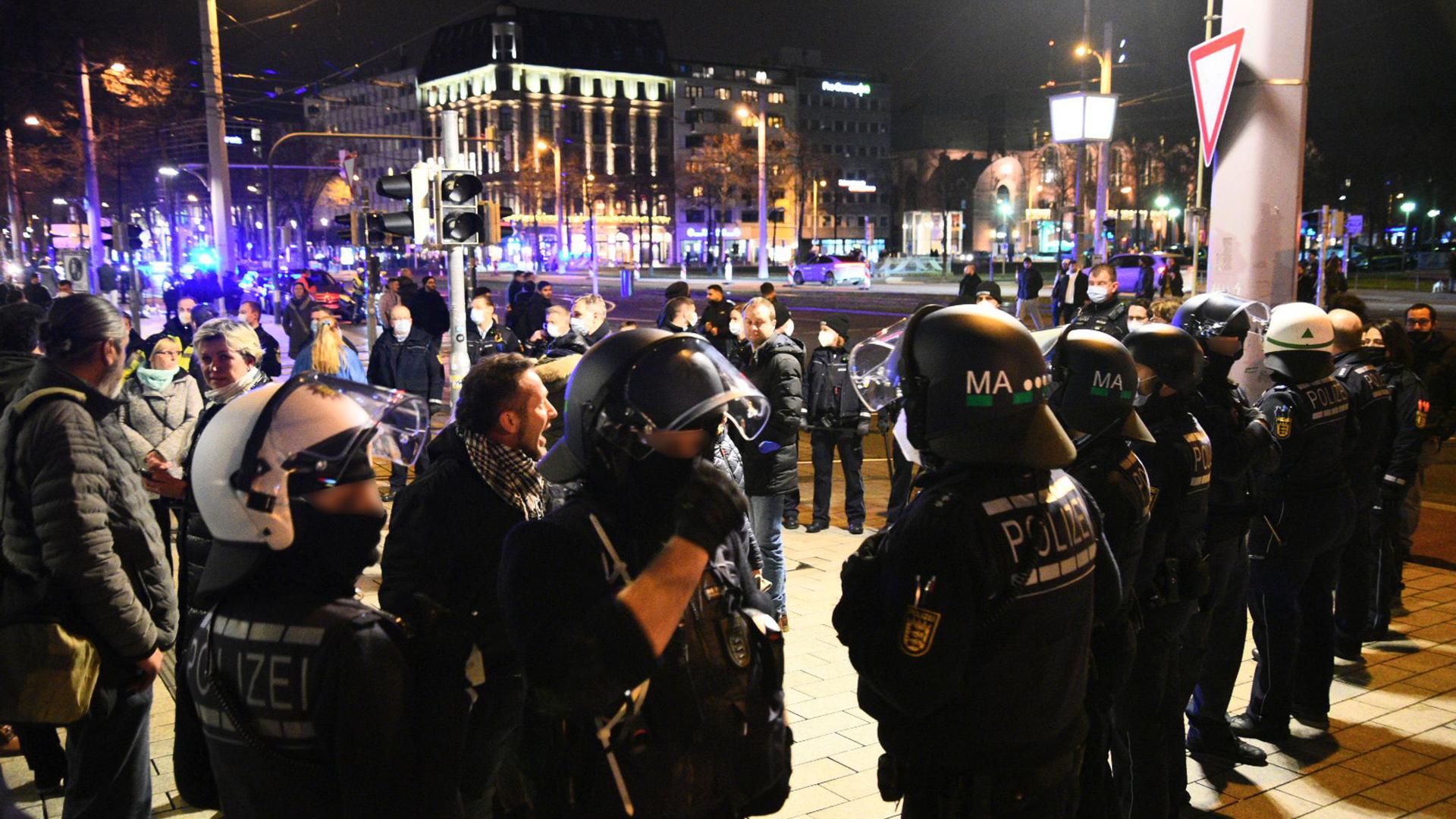Demonstranten und Polizisten stehen in der Mannheimer Innenstadt. Trotz eines Verbots zogen in Mannheim nach Schätzungen der Polizei bis zu 2000 Menschen ohne Masken und ohne Abstand durch die Stadt.