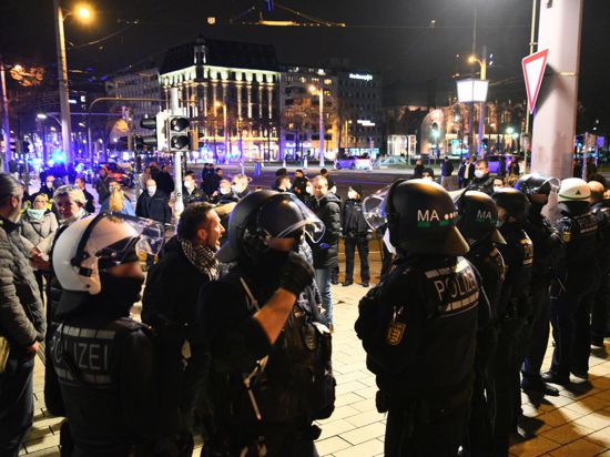 Demonstranten und Polizisten stehen in der Mannheimer Innenstadt. Trotz eines Verbots zogen in Mannheim nach Schätzungen der Polizei bis zu 2000 Menschen ohne Masken und ohne Abstand durch die Stadt.