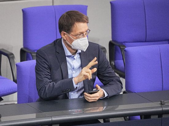 Karl Lauterbach (SPD), Bundesminister für Gesundheit, wartet auf den Beginn einer Debatte im Bundestag.