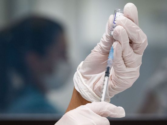 Eine werksärztliche Assistentin zieht in einem betrieblichen Impfzentrum eine Dosis des Impfstoffes von Biontech/Pfizer auf.