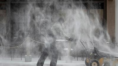 Ein Mann räumt Schnee auf dem Fußweg entlang der Fifth Street in Winston-Salem.