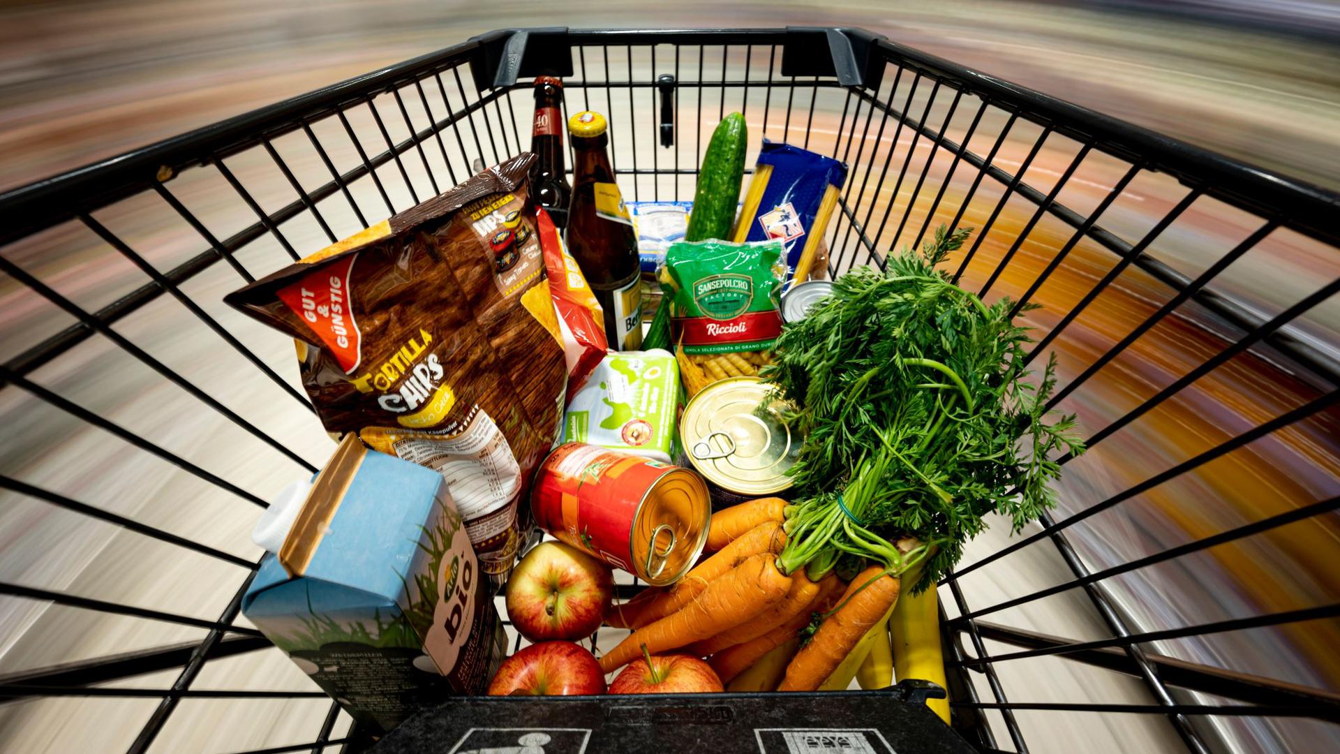 Lebensmittel liegen in einem Einkaufswagen. Lebensmittel, Energie und Kraftstoffe haben sich deutlich verteuert, die Einkommen können mit der Preisentwicklung aber nicht Schritt halten.