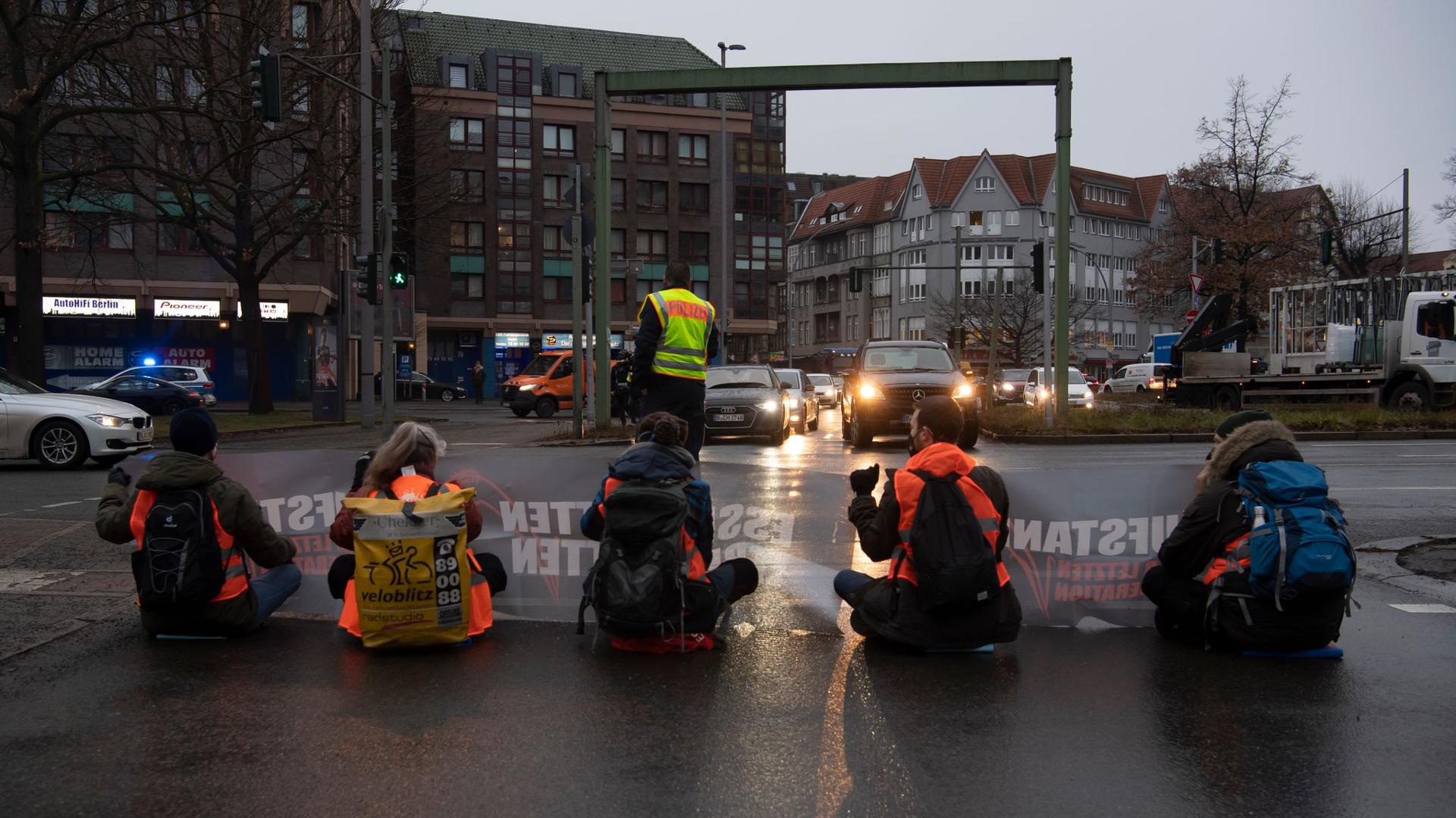 Aktivisten einer Gruppe, die sich „Aufstand der letzten Generation“ nennt, blockieren in Berlin-Steglitz die Autobahn-Zufahrt.