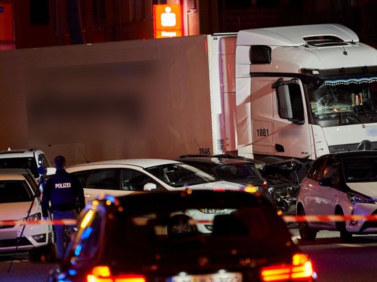 Ein Polizist dokumentiert mit einer Kamera die Unfallstelle, an der ein Lastwagen in Limburg auf mehrere vor einer roten Ampel vor dem Landgericht stehende Fahrzeuge aufgefahren ist (2019).