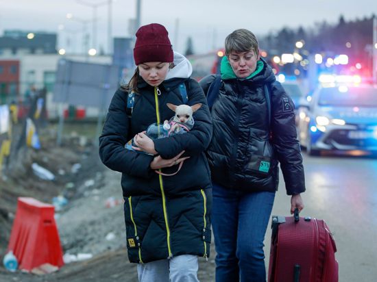 Zwei geflüchtete Frauen kommen mit einem Hund am Grenzübergang Medyka in Polen an.