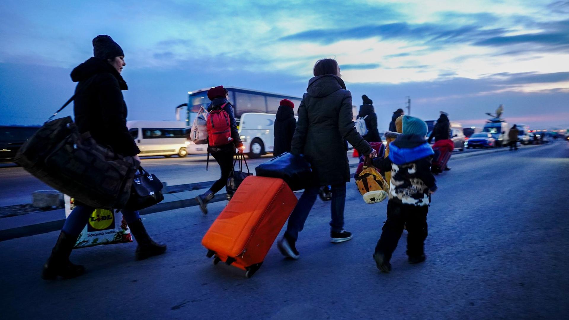 Flüchtlinge kommen am Abend über die ukrainisch-polnische Grenze in Medyka.