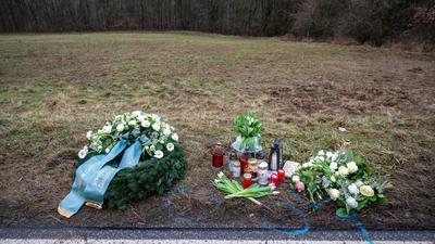 Ein Kranz sowie Blumen und Kerzen liegen am Tatort in Rheinland-Pfalz, wo zwei junge Polizisten getötet wurden.