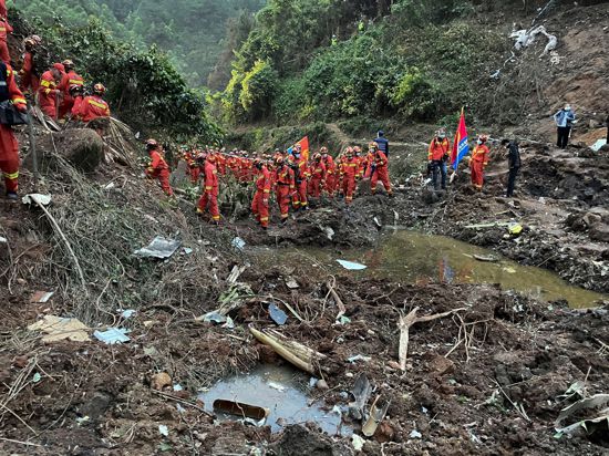 Auf diesem von der Nachrichtenagentur Xinhua veröffentlichten Foto führen Rettungskräfte Suchmaßnahmen an der Absturzstelle der Boeing 737-800 durch.