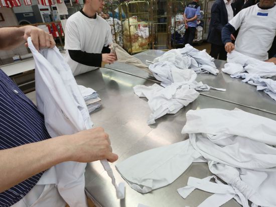 Gefangene der Justizvollzugsanstalt Plötzensee legen in der Wäscherei Wäsche zusammen.