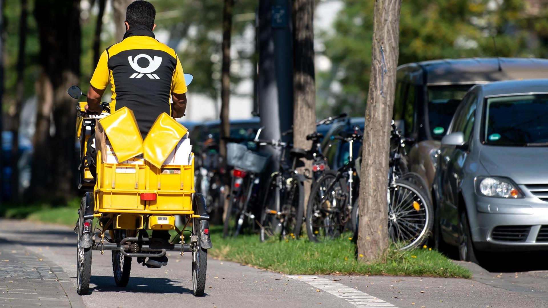 Ein Briefträger mit seinem Fahrrad: Im Jahr 2025 rechnet die Deutsche Post damit, dass fünf Briefe auf ein Paket kommen.