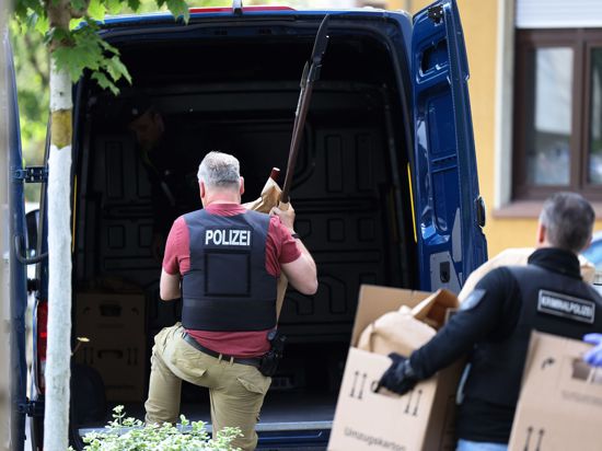 Polizisten tragen in Essen Gegenstände, darunter mehrere Stichwaffen und Speere, aus dem Wohnhaus des Verdächtigen.
