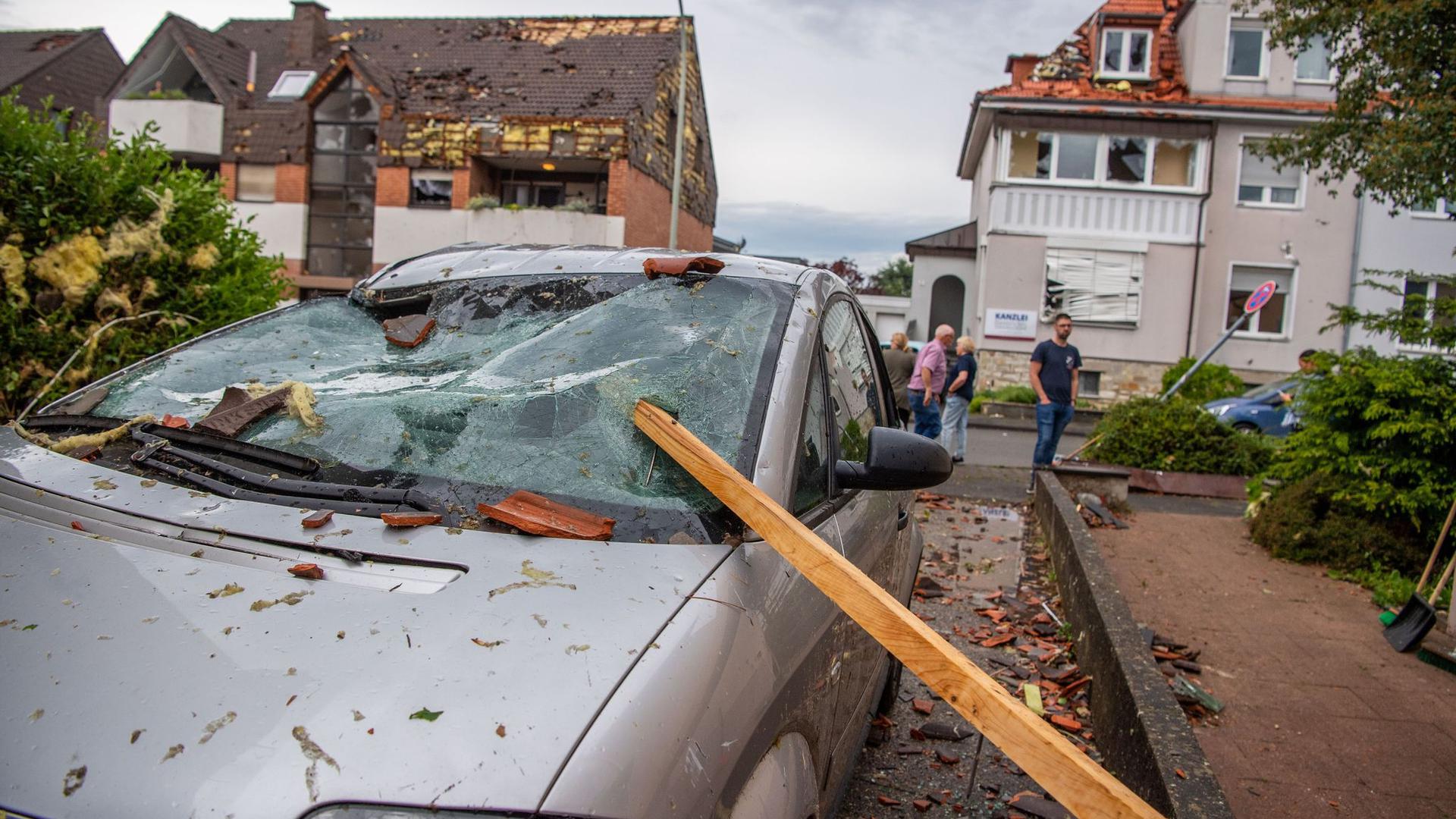 Eine Dachlatte steckt in der Windschutzscheibe eines parkenden Autos. Ein Unwetter hat auch in Paderborn große Schäden angerichtet.