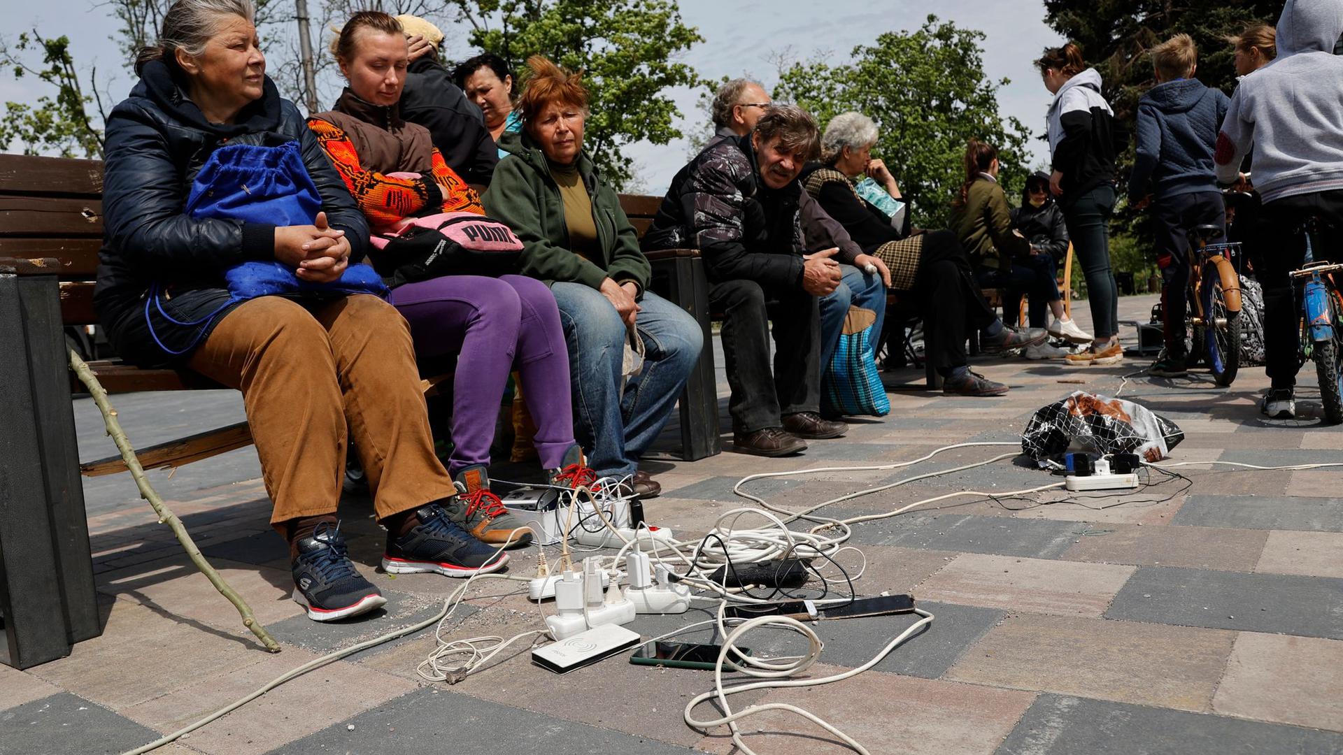 Menschen in Mariupol laden ihre Telefone auf – das Gebiet in der Ostukraine steht unter der Regierung der sogenannten Donezker Volksrepublik.