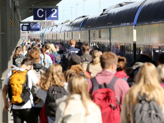 Reisende gehen am Bahnhof Westerland (Sylt) zu einem Zug in Richtung Hamburg-Altona. Das 9-Euro-Ticket soll ab heute dabei helfen, die Menschen in Deutschland dauerhaft zum Umstieg auf die Bahn zu bewegen.