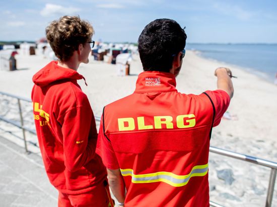 Zwei Rettungsschwimmer der DLRG bewachen einen Strand.