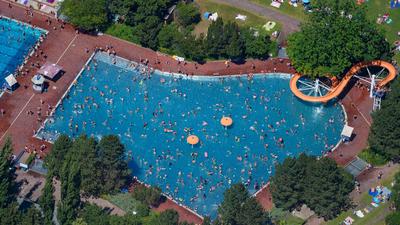 Menschen baden und sonnen sich im Sommerbad am Insulaner im Berliner Bezirk Steglitz. (Luftaufnahme).