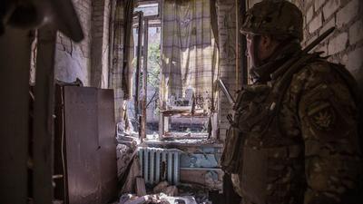 Ein ukrainischer Soldat steht während schwerer Kämpfe an der Front in Sjewjerodonezk in einer zerstörten Wohnung.