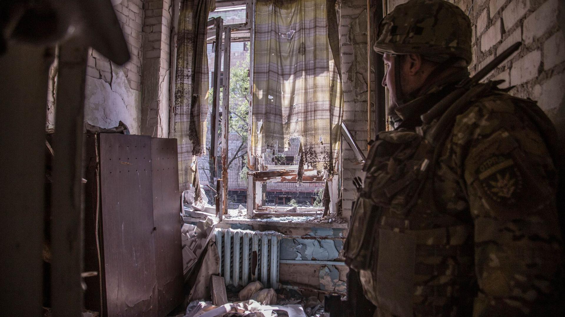Ein ukrainischer Soldat steht während schwerer Kämpfe an der Front in Sjewjerodonezk in einer zerstörten Wohnung.