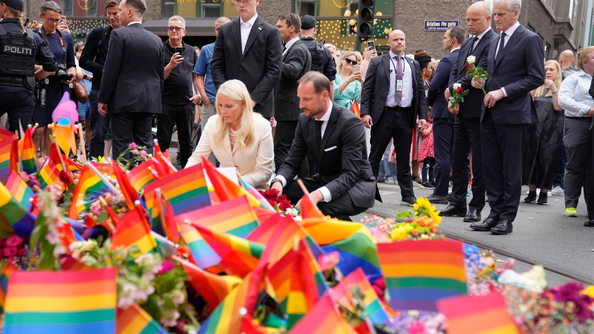 Kronprinz Haakon von Norwegen (M, r), Kronprinzessin Mette-Marit von Norwegen (M, l) und Jonas Gahr Støre (r), Regierungschef von Norwegen, legen Blumen am Tatort nieder.