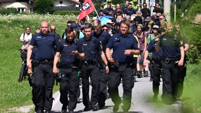 Aktivisten auf einem Sternmarsch zum G7-Gipfel werden von Polizisten begleitet.