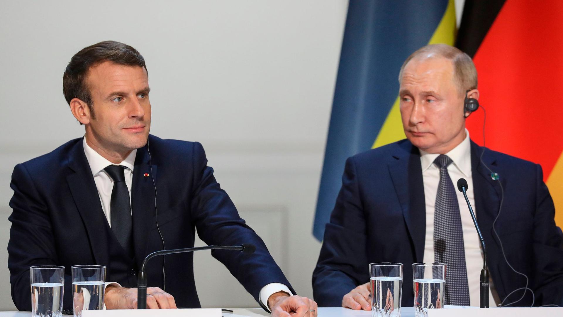 Emmanuel Macron (l), Präsident von Frankreich, und Wladimir Putin, Präsident von Russland, sitzen bei einer gemeinsamen Pressekonferenz im Pariser Schloss Elysee.