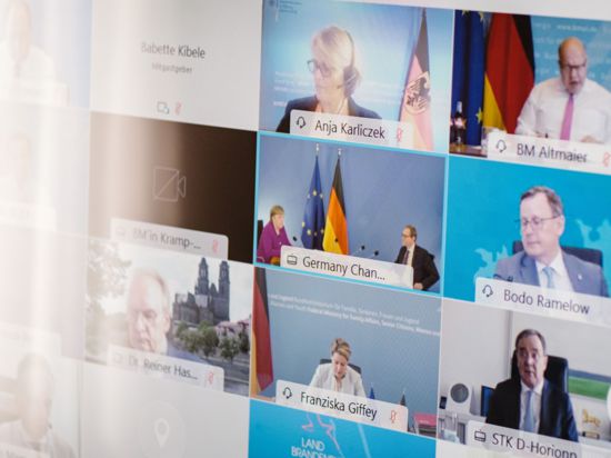 Ministerpräsidenten, Kanzlerin und weitere Vertreter der Bundesregierung sind während der Bund-Länder-Konferenz auf einem Bildschirm.