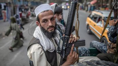 Junge Taliban-Kämpfer patrouillieren auf der Ladefläche eines Pick-Ups in den Straßen von Kabul.