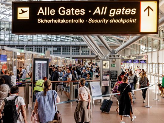 Fluggäste im Helmut Schmidt Flughafen in Hamburg vor dem Sicherheitscheck.