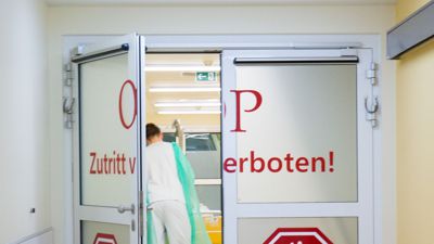 Ein Pfleger schiebt in der Asklepios Klinik Altona in Hamburg einen Patienten durch die Personenschleuse in den OP-Bereich.